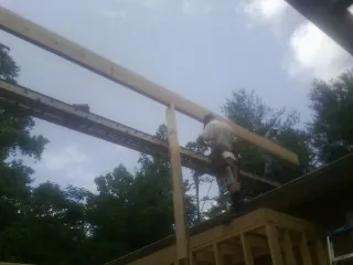 Carpenter setting a ridge beam over a new addition frame — Ice Dam Removal by Roofing Brothers in Yalaha