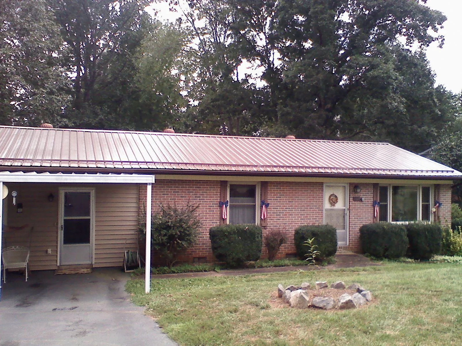 Bronze metal roof and carport on a brick ranch home — Roof Repair work by our crew in Yalaha