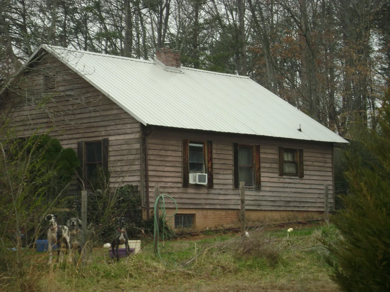 White metal roof on an old wood sided farmhouse, from a Metal Roof Installation job in Yalaha
